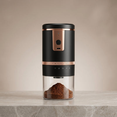 Black and rose gold portable electric coffee grinder with ground coffee